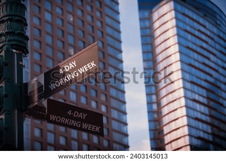 4 - Day working week on a black city-center sign in front of a modern office building Royalty-Free Stock Photo #2403145013