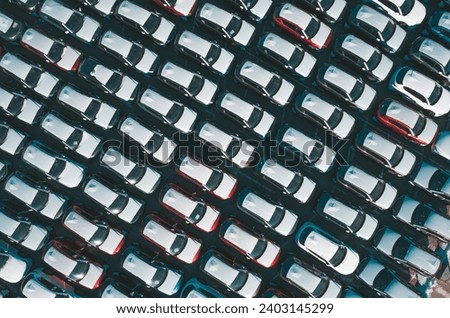 Aerial top down view of new cars parked in car parking lot. Car dealer parking lot full of new automobiles. New cars lined up for import and export business. Royalty-Free Stock Photo #2403145299