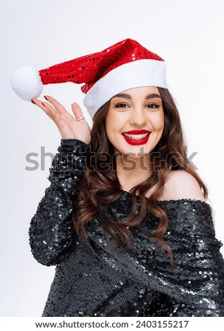 A Festive Woman Posing for a Picture in a Santa Hat. A woman wearing a santa hat posing for a picture
