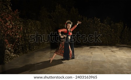 a Balinese dancer looks graceful when moving his hands and feet on stage very agilely at night