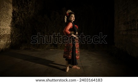 an Indonesian dancer wearing jewelry that shines under the spotlight of the stage lights adds to the brilliance of the performance that night
