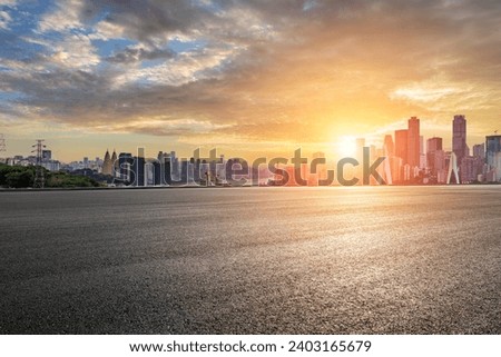 Empty asphalt road and city buildings skyline at sunset in Chongqing