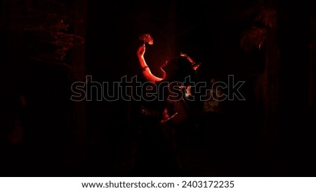 silhouette of a female dancer holding jewelry in the middle of the stillness of the night with red light at night