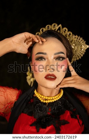 a Sundanese dancer wearing gold jewelry which gives a luxurious feel to her appearance on stage at night