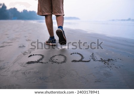 New Year 2024 New Start resolution concept photo, men walking at beach over 2024 number