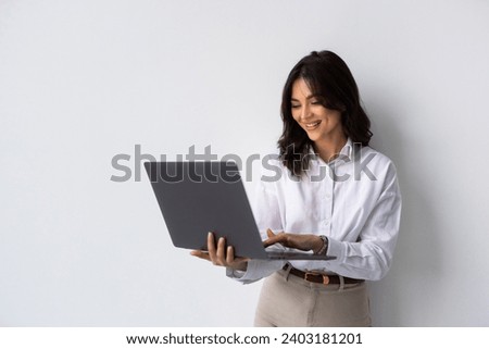 Portrait of a happy asian businesswoman working on laptop computer isolated over white background