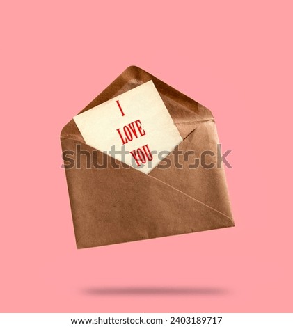 Vintage kraft paper evelope with paper sheet with inscription i love you on pink background. Love letter concept. Royalty-Free Stock Photo #2403189717