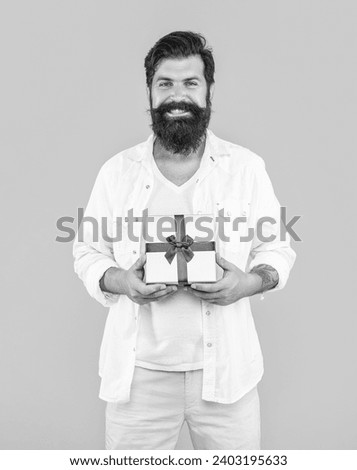 smiling man with present box isolated on yellow. man with present box in studio.