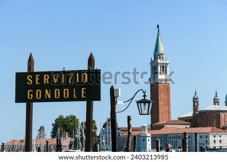 Sign indicating Gondola service at Saint Mark square in city of Venice, Veneto, Northern Italy, Europe. Scenic view of San Giorgio di Maggiore church in the back. Romantic vacation in Venetian Lagoon