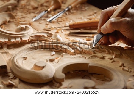 Wood carving tools. Carpenters hands use chisel. Senior wood carving professional during work. Man working with woodcarving instrument. Royalty-Free Stock Photo #2403216529