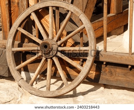Old wooden hand-wrought cart wheel.