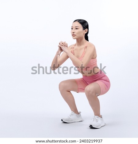 Vigorous energetic woman doing exercise. Young athletic asian woman strength and endurance training session as squat workout routine session. Full body studio shot on isolated background. Royalty-Free Stock Photo #2403219937