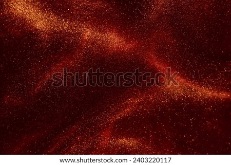 Various stains and overflows of gold particles with burgundy tints. Beautiful flying shiny golden particles on a red background. Magic Galaxy of golden dust particles in red fluid. Royalty-Free Stock Photo #2403220117