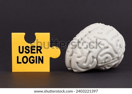 On a black surface there is a brain and a yellow puzzle with the inscription - User login. Business and technology concept.
