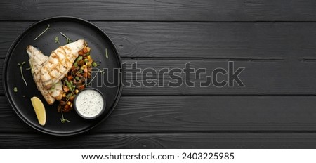 Grilled perch fillet served on a plate on a dark wooden background. Top view, flat lay. Banner. Copy space Royalty-Free Stock Photo #2403225985