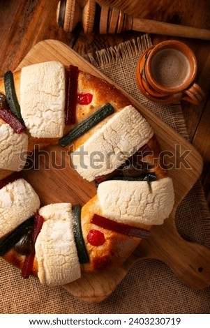 Three Kings Bread also called Rosca de Reyes, Roscon, Epiphany Cake, traditionally served with hot chocolate in a clay Jarrito. Royalty-Free Stock Photo #2403230719
