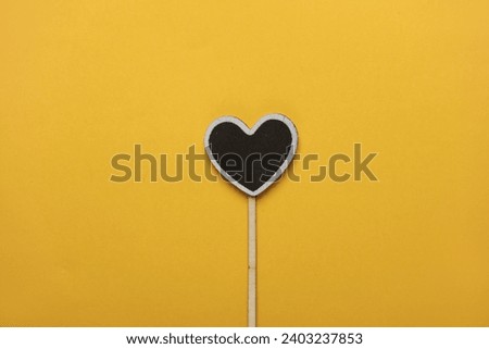 Chalkboard label, blank wooden blackboard tag, heart shaped garden sign on yellow background