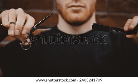 Barber man hold scissors on brick background. Card for Barbershop hairdresser salon, retro toning.