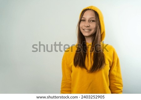 young pretty blonde girl cute face expression posing in yellow hoodie on grey bright background isolated, emotional, funny. Fashionable young beautiful teen girl