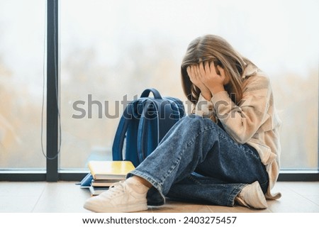 A Unhappy depress Pre teen girl at school. Royalty-Free Stock Photo #2403275457