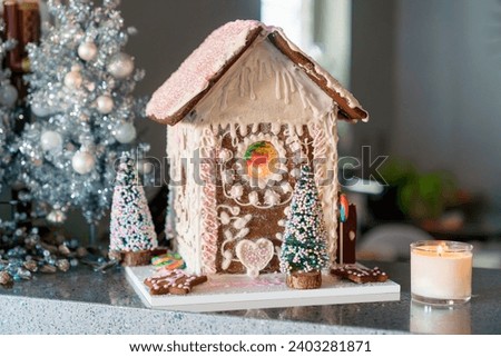 Gingerbread house with white and pink icing. Landscape horizontal front view.