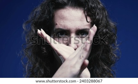 Woman waving finger saying "NO" with body language. Female person in 20s rejecting approach Royalty-Free Stock Photo #2403288067