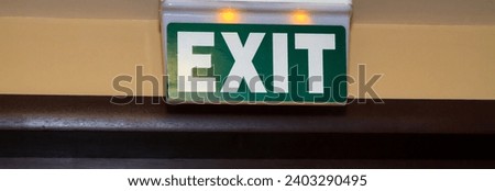 Green emergency exit sign in public building.