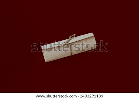Close-up of gift wrapping with twine bow on dark red background. Background of a greeting card, a letter with congratulations
