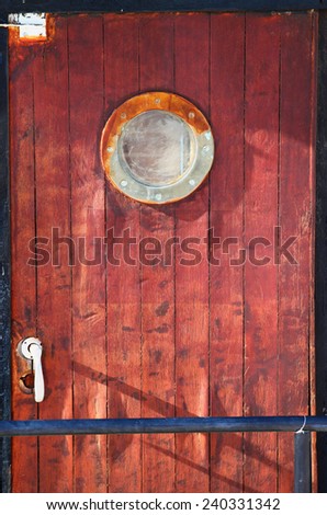 picture of old ship door with a round window