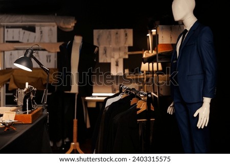 Exquisite professional tailoring studio full of premium quality bespoken sartorial collection and fashion design sketch drawings on walls. Atelier shop with stylish elegant clothing on mannequins