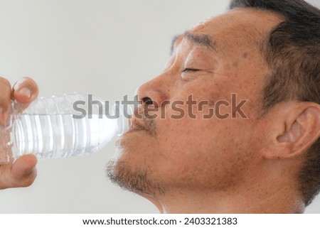 Happiness of male elderly holding a bottle of water. Senior people drinking fresh mineral water. Royalty-Free Stock Photo #2403321383