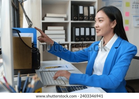 Office worker, attractive Asian businesswoman sitting and working with PC regarding financial information, marketing, online in company business. Management concept.