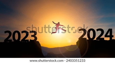 New Year 2024 concept.Businessman jumping on cliff 2024 over the precipice at amazing sunset.Reopening for business and lifestyle,new normal,challenge,career path,change,starting,readiness of leaders Royalty-Free Stock Photo #2403351233