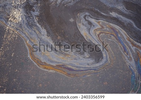 Oil, gasoline, or oil spill on wet asphalt with a parking lot and a dividing line Royalty-Free Stock Photo #2403356599