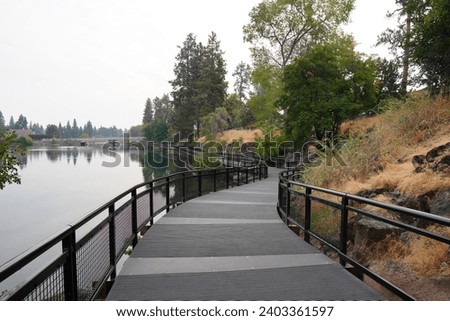 Walking path along the Deschutes River at Drake Park in Bend, Oregon Royalty-Free Stock Photo #2403361597