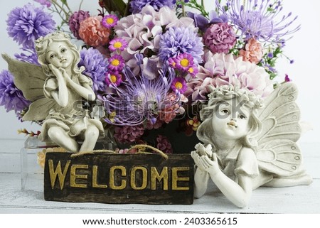 Welcome sign with flowers bouquet and angel statues home decorations