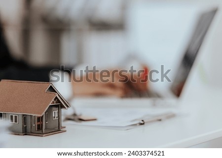 real estate agent Small house model on the table mortgage loan contract Make a contract to buy and sell a house. and home insurance contract home mortgage loan concept
