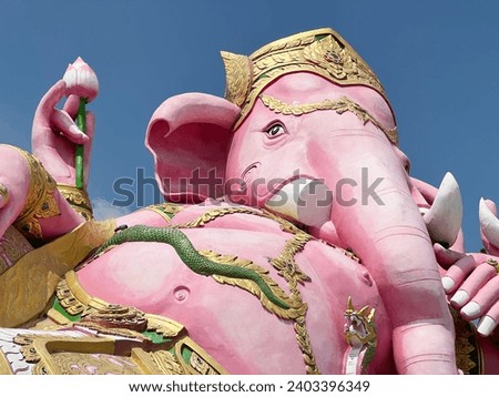 pink ganesh statue on blue sky, thailand