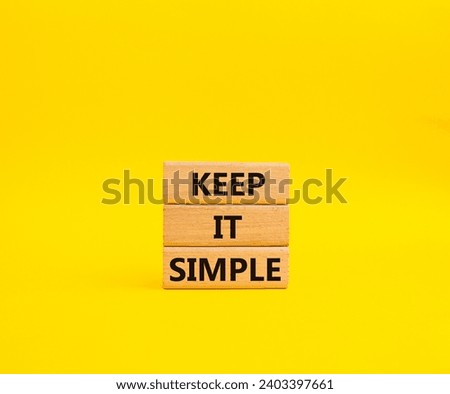 Keep it Simple symbol. Concept words Keep it Simple on wooden blocks. Beautiful yellow background. Business and Keep it Simple concept. Copy space.