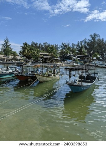 The picture shows the small fishing boats tied up at the jetty after finishing the work of catching fish in the ocean. Photo taken at noon in Terengganu, Malaysia.