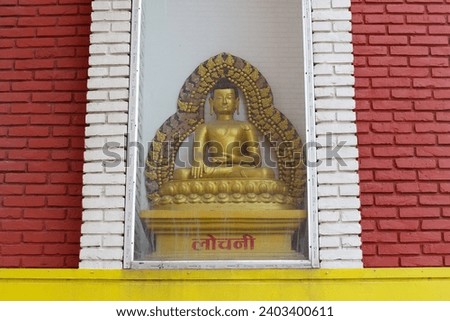 A statue of a meditating Buddha with "Lochani" inscription in Nepali language. Royalty-Free Stock Photo #2403400611