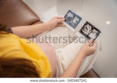 A pregnant woman looks at the ultrasound results of her unborn child.