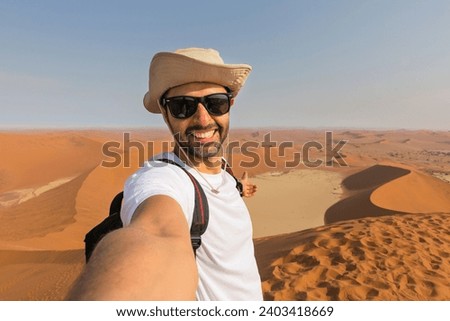Happy tourist taking selfie on sand dunes in the Namib desert - Namibia