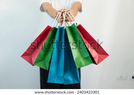 Women are carrying various colorful shopping bags. Close-up photo of shopping concept
