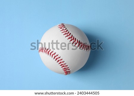 One baseball ball on light blue background, top view