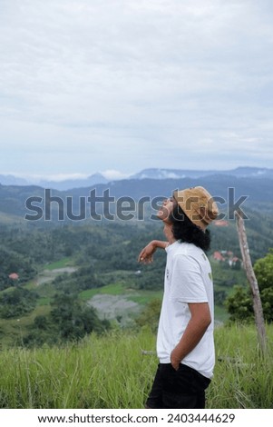 Asian youth stand in the grasslands and breathe fresh air in the afternoon