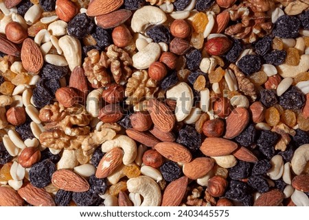 Mixed Nuts: Almonds, Walnuts, Cashews, Peanuts, Hazelnuts, Dried Prunes and Raisins. Different Nut Mix. Background from Various Nuts and Dried Fruits Royalty-Free Stock Photo #2403445575