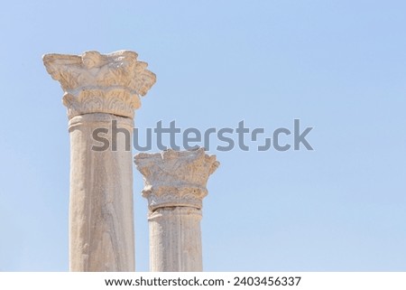 Corinthian capitals (partially ruined) and columns. Isolated, clear blue sky at background. Copy space. Side ancient city, Turkey (Turkiye). Design or art history concept