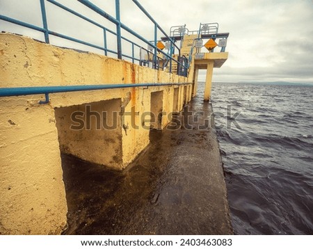 Famous Blackrock diving board in Salthill area of Galway city, Ireland. Cloudy sky over the ocean. Town landmark and tourist viewpoint with stunning Irish nature scenery. Vertical image