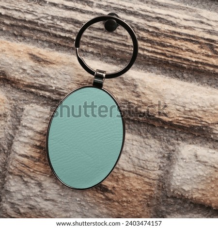Metal and leather keychains. Teal color one side leather; Square, rectangle and circle shaped key rings. Concept shots, photos taken specially for e-commerce sales. Stone wall background.
